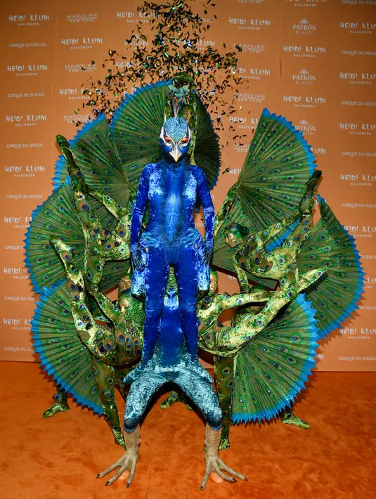 <p>Yang menarik, ia mesti ditemani oleh sembilan orang lain untuk membuat kostumnya lengkap. Ada yang didandani sebagai kaki merak, hingga ekor burung jantan yang berwarna-warni. (Photo by Evan Agostini/Invision/AP)</p>
