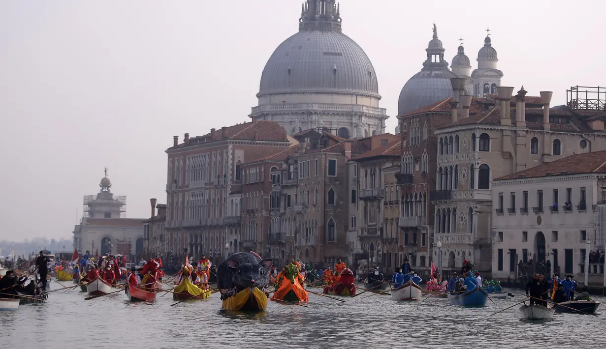 Peserta mendayung perahu berbentuk tikus raksasa menyusuri Grand Canal pada pembukaan karnaval Venesia di Italia, 28 Januari 2018. Karnaval perahu Venisia dengan aneka kostum terus berlangsung hingga saaat ini. (AFP Photo / FILIPPO MONTEFORTE)