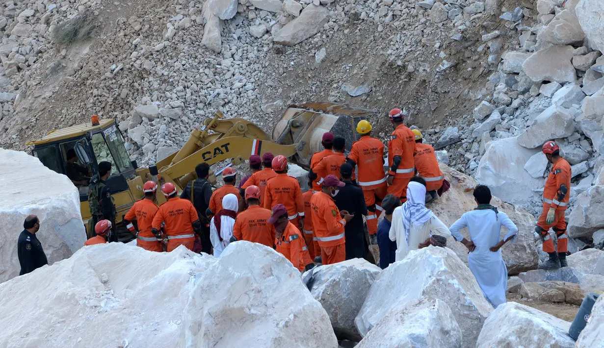 Petugas penyelamat melakukan pencarian korban di lokasi tambang marmer yang longsor di Mohmand, Pakistan, dekat perbatasan Afghanistan, Selasa (8/9/2020).  Sedikitnya 18 penambang tewas dan lebih dari selusin masih terjebak longsor yang terjadi pada Senin (7/9) malam. (AP Photo/Zubair Khan)