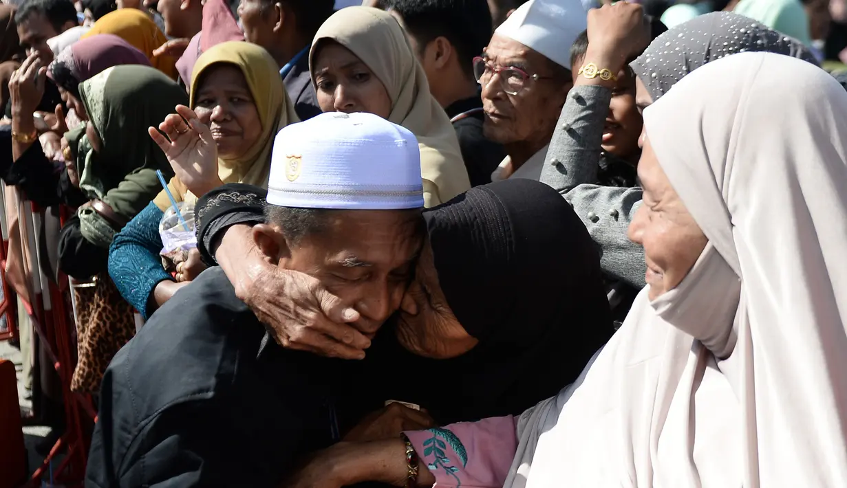 Seorang wanita mencium jemaah calon haji yang akan bertolak ke Tanah Suci Mekah di Bandara Provinsi Narathiwat, Thailand, Kamis (4/7/2019). Jutaan umat muslim dari penjuru dunia akan bertolak menuju Mekah untuk melangsungkan ibadah haji. (Madaree TOHLALA/AFP)