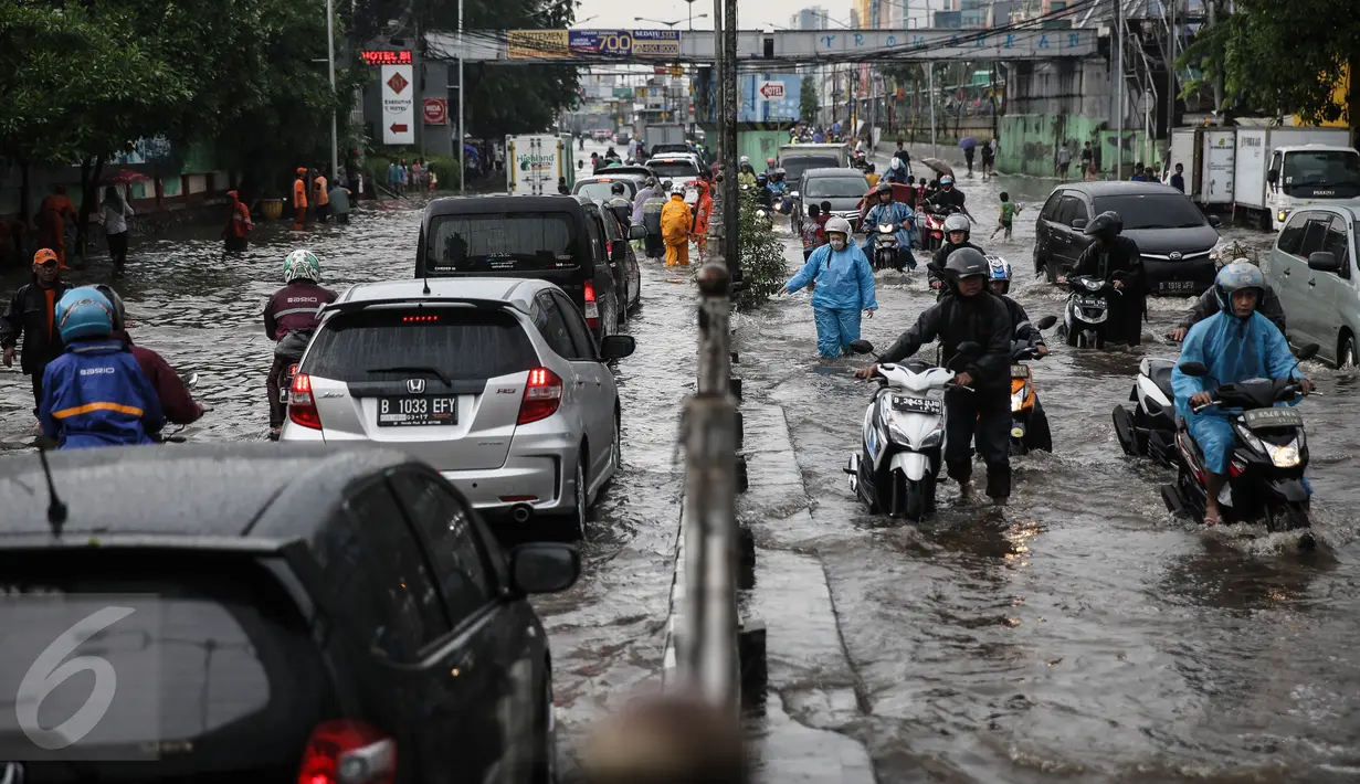 Warga mendorong sepeda motornya saat menerobos banjir di jalan depan Ancol, Jakarta, Kamis (21/4). Hujan deras yang mengguyur sejak semalam menyebabkan beberapa kawasan di Jakarta tergenang banjir. (Liputan6.com/Faizal Fanani)