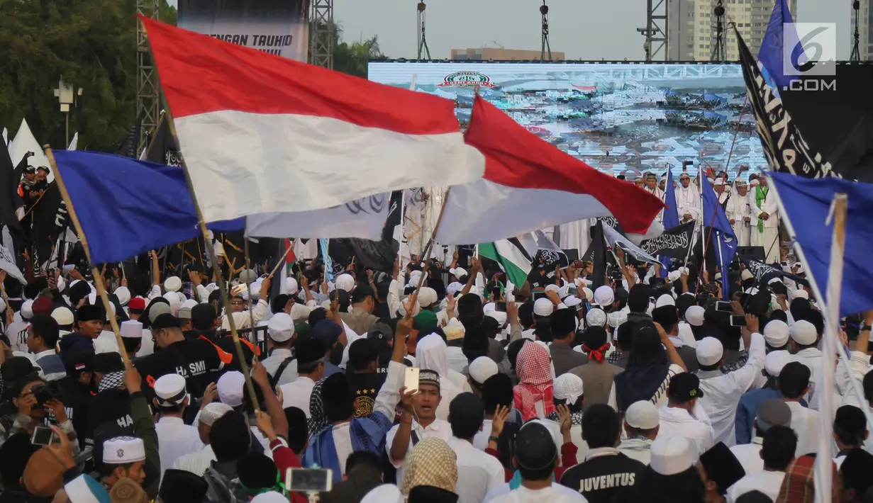 Umat muslim mengikuti aksi reuni 212 di kawasan silang Monas, Jakarta, Minggu (2/12). Bendera dan panji-panji terlihat diusung para peserta aksi reuni akbar 212. (Liputan6.com/Herman Zakharia)