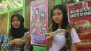 Pengunjung berfoto dengan ular di Taman Margasatwa Semarang, Sabtu (16/6). Hari kedua lebaran, warga bertamasya ke Taman Margasatwa Semarang di Daerah Mangkang Semarang. (Liputan6.com/Gholib)