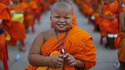 Seorang Biksu Buddha tersenyum saat menunggu acara penerimaan sedekah di kuil Wat Phra Dhammakaya, Bangkok, Thailand, (22/4). Kegiatan ini juga sebagai penasbihan para bhikkhu dan samanera atau calon Biksu. (REUTERS / Jorge Silva)
