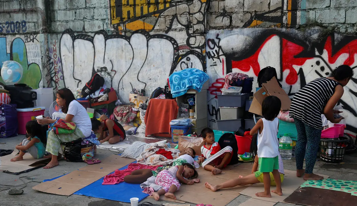 Sejumlah anak beristirahat usai rumahnya hangus terbakar di  Quezon, Metro Manila di Filipina (28/12). Menurut laporan, sekitar 500 rumah ludes terbakar dan sekitar 1.000 keluarga telah diungsikan. (REUTERS/Erik De Castro)
