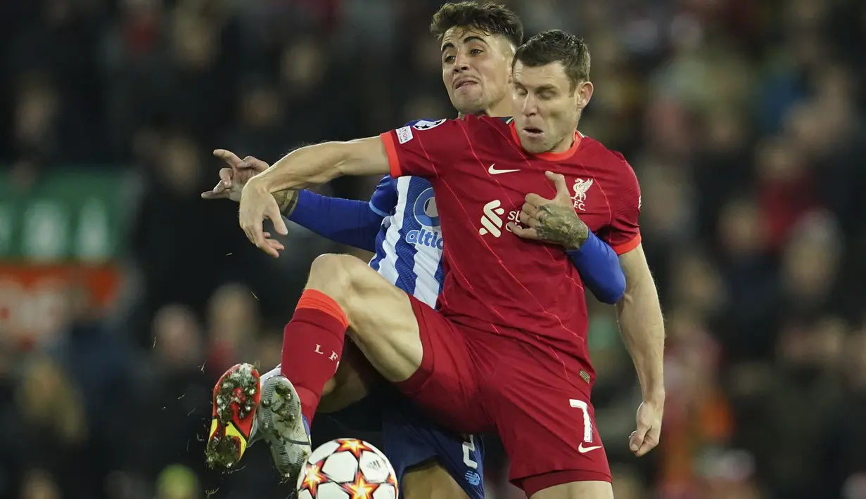 Gelandang Liverpool James Milner dan bek FC Porto Fabio Cardoso berebut bola pada pertandingan kelima Grup B Liga Champions di Anfield, Kamis (25/11/2021) dini hari WIB. Kemenangan Liverpool 2-0 atas sang tamu FC Porto dipersembahkan oleh gol Thiago Alcantara dan Mohamed Salah. (AP Photo/Jon Super)