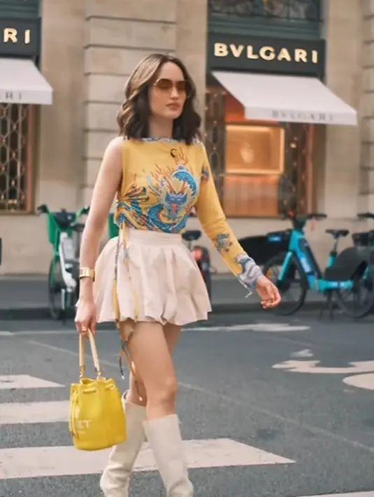 Adalah Buckget Bag dari Marc Jacobs warna kuning yang senada dengan atasannya seharga Rp6,3jutaan [@claurakiehl]