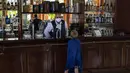 Seorang turis muda meminta minuman ringan kepada pelayan di hotel Iberostar Selection Varadero di Varadero, Kuba, Rabu (29/9/2021). Pihak berwenang di Kuba mulai melonggarkan pembatasan COVID-19 di beberapa kota seperti Havana dan Varadero. (AP Photo/Ramon Espinosa)