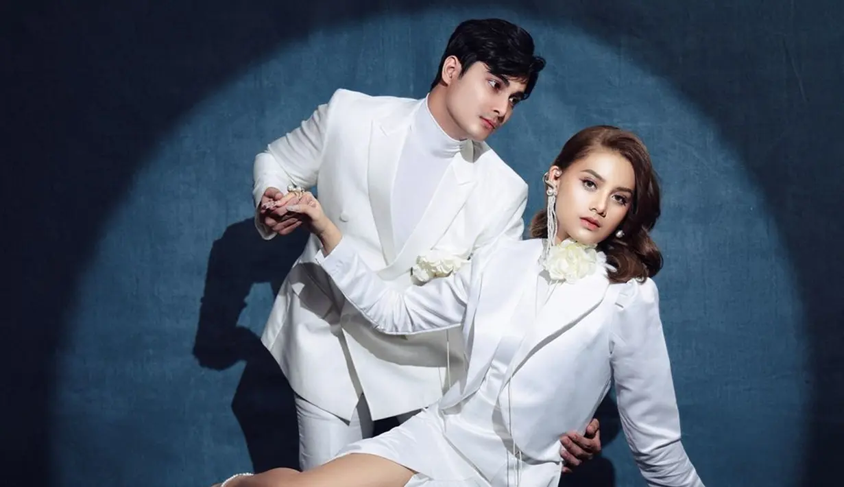 Tema dari pemotretan Callista Arum dan Cinta Brian ini adalah Is This Love. Callista Arum mengenakan dress putih dibalut blazer warna senada. Bros bunga yang dipasang di kerah bajunya mendukung penampilannya makin menawan. Sementara Cinta Brian tampan dengan baju setelan putih dan bros bunganya dipasang di kantong jas putih yang dikenakannya. (Liputan6.com/IG/@callistarum)