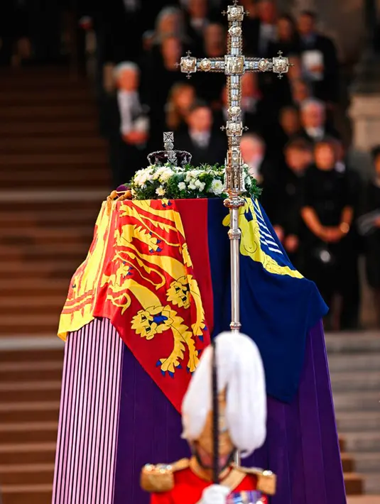 Seorang anggota King's Body Guards of the Honorable Corps of Gentlemen at Arms berjaga di sekitar peti jenazah Ratu Elizabeth II di Westminster Hall, Istana Westminster, London, Inggris, 14 September 2022. Persemayaman ini untuk memberi kesempatan bagi publik memberikan penghormatan terakhir.  (Oli Scarff/Pool via AP)