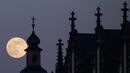 Bulan purnama tampak di belakang gereja Deutschorden dan atap gereja Dreikönig di Frankfurt am Main, Jerman barat, (10/5). (AFP Photo/dpa/Frank Rumpenhorst/Germany Out)