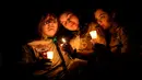 Orang-orang berkumpul untuk para korban penembakan massal minggu ini di Lisbon Falls, Maine, Amerika Serikat, Sabtu (28/10/2023). Mereka menyalakan lilin untuk mengenang para korban yang tewas dalam penembakan massal di Maine. (AP Photo/Matt Rourke)