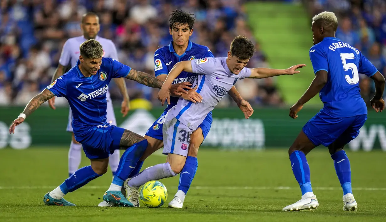 Pemain Barcelona Gavi (tengah) berebut bola dengan pemain Getafe Mathias Olivera (kiri) dan Chema (tengah) pada pertandingan sepak bola La Liga di Stadion Coliseum Alfonso Perez, Getafe, Spanyol, 15 Mei 2022. Pertandingan berakhir imbang 0-0. (AP Photo/Manu Fernandez)