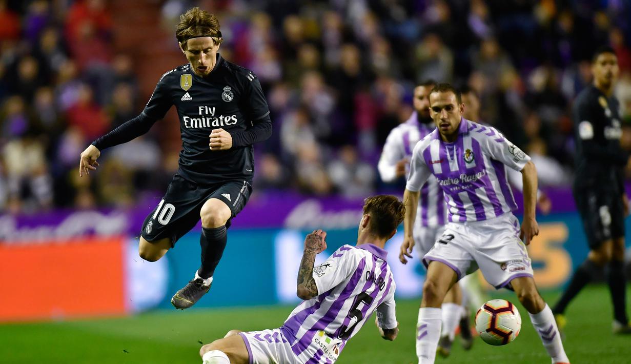 Gelandang Real Madrid, Luka Modric berusaha melewati pemain Real Valladolid, Luismi Sanchez selama pertandingan lanjutan La Liga Spanyol di stadion Jose Zorrilla,Valladolid (10/3). Madrid menang telak 4-1 atas Valladolid. (AP Photo/Alvaro Barrientos)