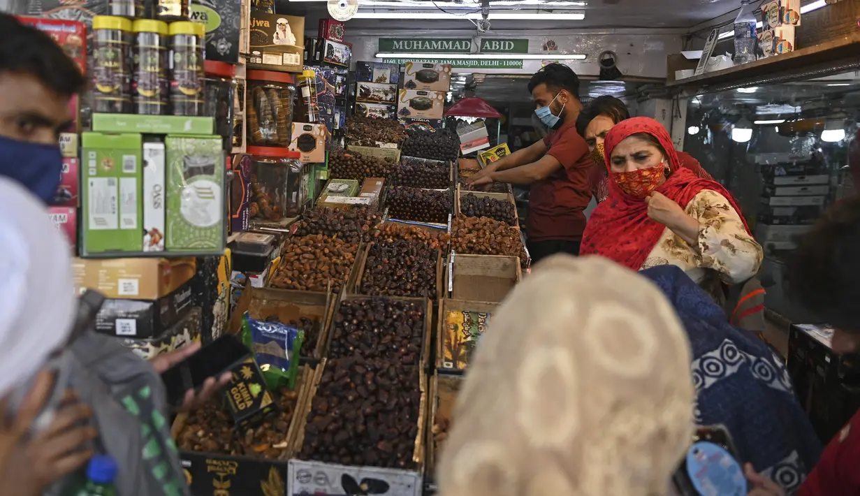 Orang-orang membeli kurma di sepanjang jalan untuk bulan suci Ramadhan di Delhi, India pada Selasa (13/4/2021). Kurma sangat identik dengan bulan Ramadhan, karena buah yang satu ini kerap dijadikan pengisi menu sahur dan berbuka puasa. (Sajjad HUSSAIN / AFP)