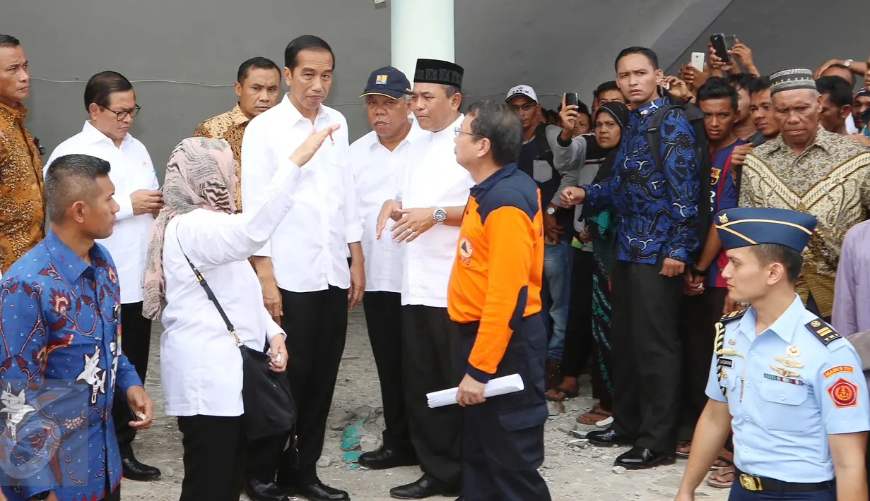 Presiden Joko Widodo (Jokowi) mendengarkan penjelasan terkait robohnya masjid At-Taqarrub di Pidie Jaya, Aceh, Jumat (9/12). Masjid At-Taqarrub merupakan salah satu bangunan masjid yang roboh akibat gempa 6,5 SR itu.  (Liputan6.com/Angga Yuniar)