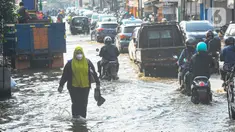 Warga berjalan melewati banjir yang menggenangi kawasan perempatan Mampang, Depok,Senin Rabu (19/6/2023). (merdeka.com/Arie Basuki)
