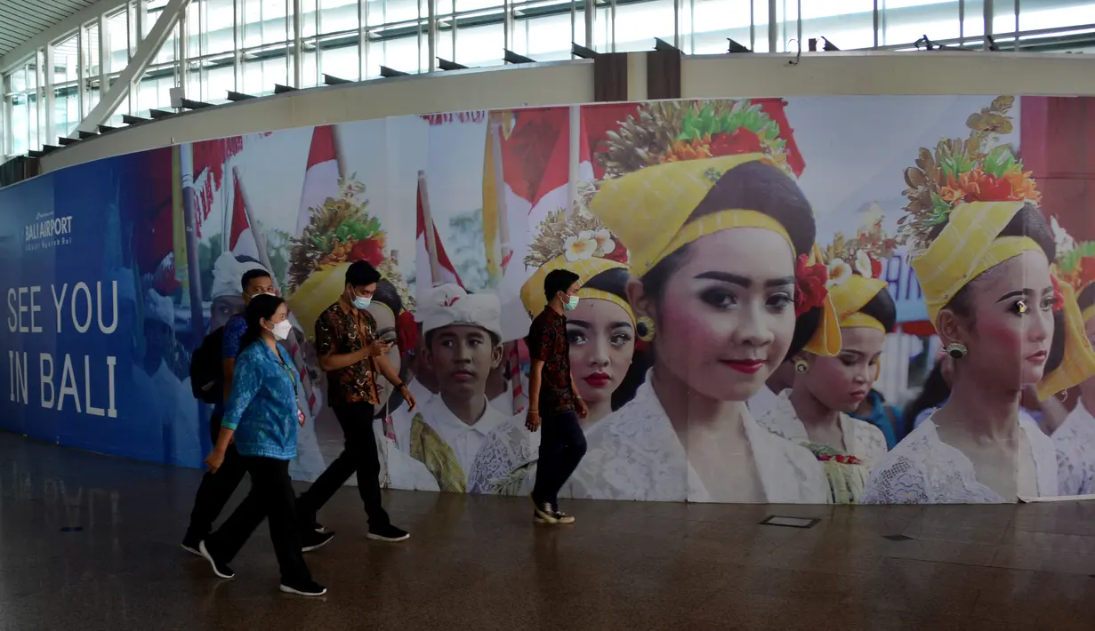 Orang-orang berjalan di area kedatangan internasional yang hampir kosong di bandara Ngurah Rai di Tuban dekat Denpasar di pulau resor Bali (5/10/2021).  Bandara Ngurah Rai akan kembali dibukan pada 14 Oktober untuk beberapa pelancong internasional. (AFP/Sony Tumbelaka)