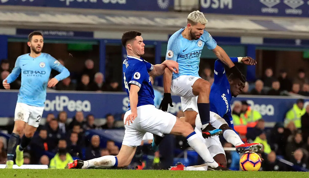 Striker Manchester City, Sergio Aguero berusaha melewati dua pemain Everton, Idrissa Gueye dan Michael Keane selama pertandingan lanjutan Liga Inggris di Goodison Park Stadium (6/2). City menang atas Everton 2-0. (Peter Byrne/PA via AP)