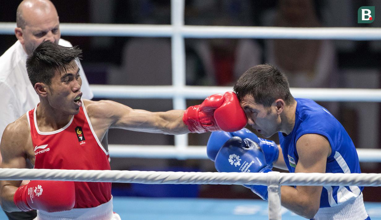 Aksi petinju asal Indonesia Sunan Agung Amoragam saat melawan Mirazizbek Mirzakhalilov asal Uzbekistan di babak semifinal kelas bantam (56 kg) Asian Games 2018 di JIExpo Kemayoran Jakarta pada Jumat (31/8/2018). (Bola.com/Peksi Cahyo)