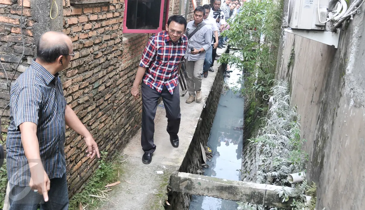 Cagub DKI Basuki Tjahaja Purnama ( Ahok ) menyusuri saluran air saat blusukan ke wilayah Cililitan, Jakarta, Rabu (28/12). Dalam blusukannya tersebut Ahok mencari tahu permasalahan banjir di Cililitan Kecil. (Liputan6.com/Yoppy Renato)