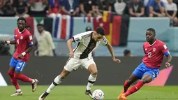 Penyerang Jerman, Jamal Musiala berusaha melewati pemain Kosta Rika, Joel Campbell selama pertandingan grup E Piala Dunia 2022 Qatar di Stadion Al Bayt di Al Khor, Qatar, Jumat (2/12/2022). Tim asuhan Hansi Flick ini kalah selisih gol dari Spanyol yang kalah 1-2 dari Jepang. (AP Photo/Moises Castillo)