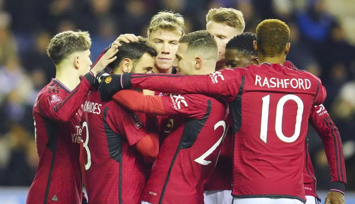 Para pemain Manchester United merayakan gol yang dicetak oleh Bruno Fernandes ke gawang Wigan Athletic dalam laga putaran ketiga FA Cup 2023/2024 di DW Stadium, Selasa (9/1/2024) dini hari WIB. Di babak 32 besar tersebut, Setan Merah akan berhadapan dengan pemenang laga replay antara Easleigh vs Newport County. (AP Photo/Jon Super)