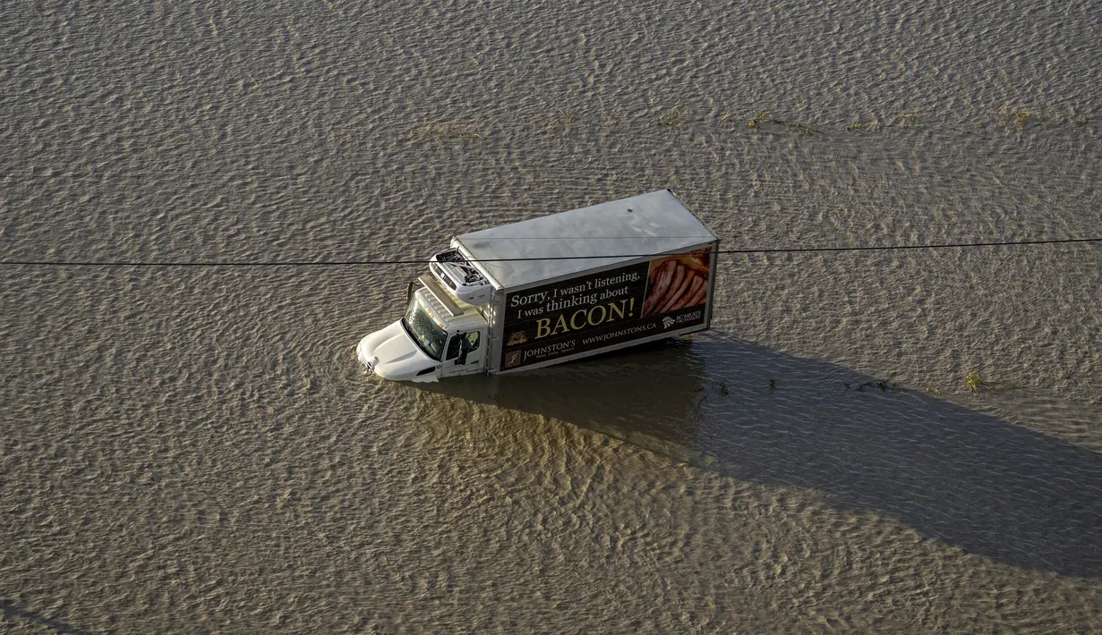 Sebuah truk terdampar di jalan yang banjir di Abbotsford, British Columbia, Kanada, Selasa (16/11/2021). Banjir juga telah menutup banyak jalan raya, termasuk semua rute utama ke Vancouver. (Jonathan Hayward/The Canadian Press via AP)
