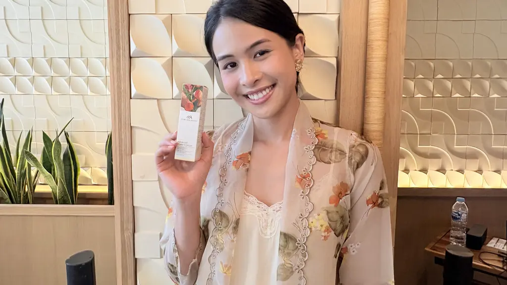 Maudy Ayunda memegang serum terbaru dari From This Island  berbahan dasar kunyit. [Anisha/Fimela]