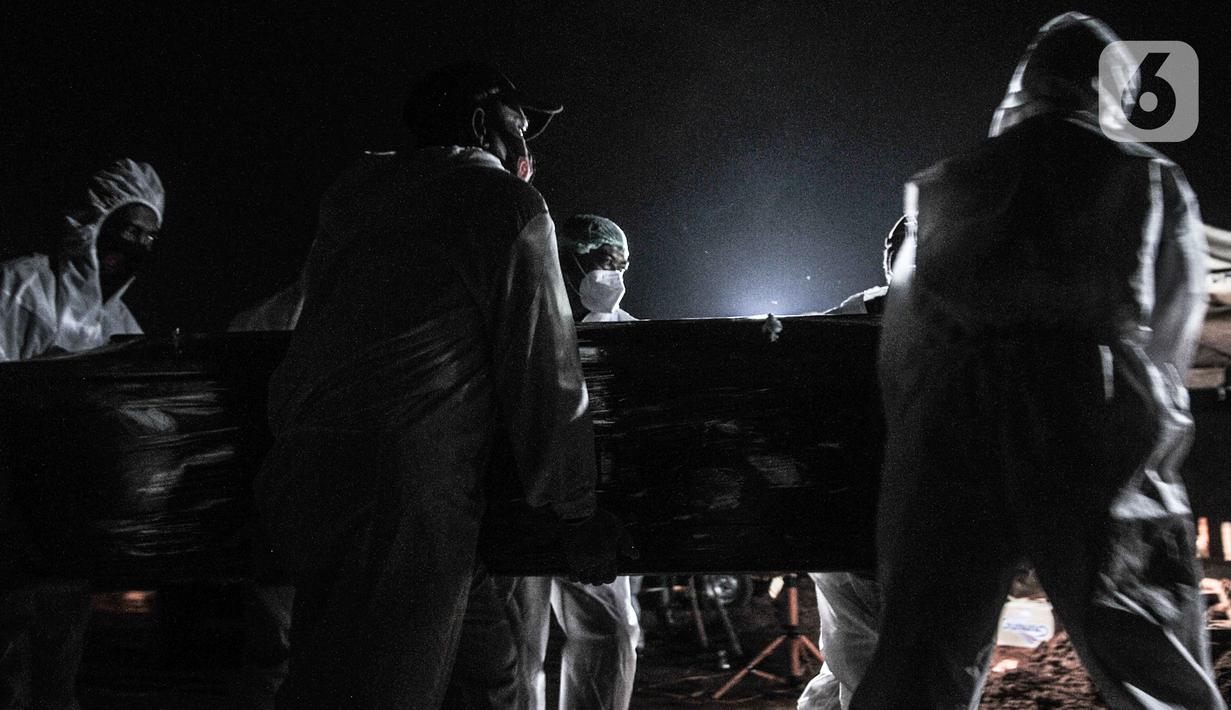 Petugas mengenakan alat pelindung diri (APD) dan baju hazmat saat proses pemakaman pasien Covid-19 di TPU Pondok Ranggon, Jakarta, Kamis (24/9/2020). Jumlah kumulatif kasus Covid-19 di Indonesia mencapai 262.022 orang per Kamis (24/9) dengan 10.105 jiwa meninggal dunia. (merdeka.com/Iqbal Nugroho)