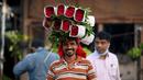 Seorang pedagang membawa seikat mawar jelang Festival Diwali di pasar bunga New Delhi, India, Minggu (31/10/2021). Festival Diwali atau Festival Cahaya dalam agama Hindu melambangkan kemenangan baik atas buruk. (Money SHARMA/AFP)