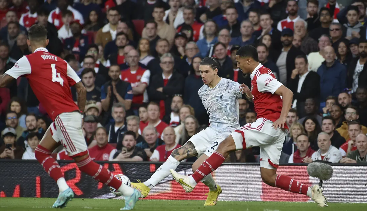 Penyerang Liverpool, Darwin Nunez berusaha mengumpan bola dari kawalan pemain Arsenal, William Saliba dan Ben White selama pertandingan lanjutan Liga Inggris di Stadion Emirates di London, Minggu (9/10/2022). Arsenal menang tipis atas Liverpool dengan skor 3-2. (AP Photo/Rui Vieira)
