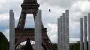 Pengunjung meluncur dengan seutas tali saat melakukan permainan Zip Line dari lantai dua Menara Eiffel di atas taman Champ de Mars, Paris, Selasa (28/5/2019). Kegiatan yang mirip dengan flying fox ini dipasangkan di atas ketinggian 115 meter dengan kecepatan 30 km per jam. (AP/Francois Mori)
