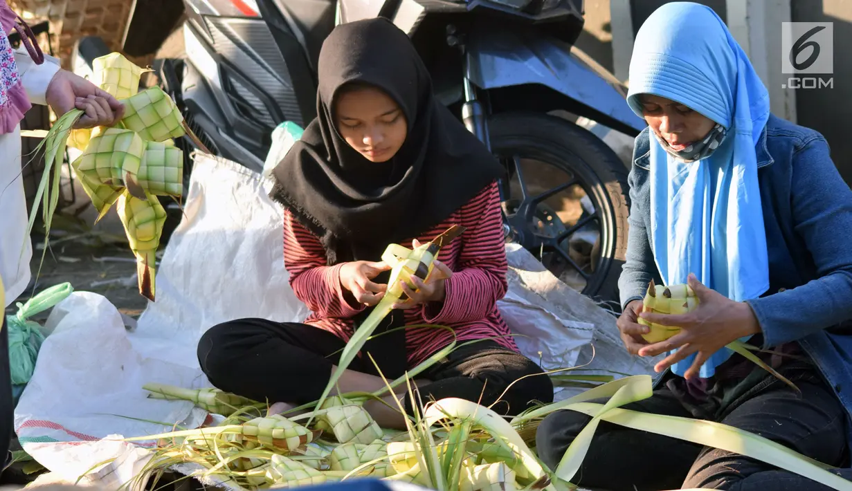 Pedagang merangkai janur menjadi kulit ketupat di Pasar Peterongan Semarang, Jawa Tengah, Kamis (14/6). Penjualan ketupat dan janur mulai marak menjelang lebaran dengan harga Rp 12.000 per sepuluh ketupat. (Liputan6.com/Gholib)