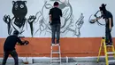 Sejumlah seniman grafiti membuat mural harimau kumbang di Bangkok, Thailand (16/3). Aksi ini sebagai protes perburuan liar ilegal oleh konglomerat konstruksi Premchai Karnasuta. (AFP Photo/Lillian Suwanrumpha)