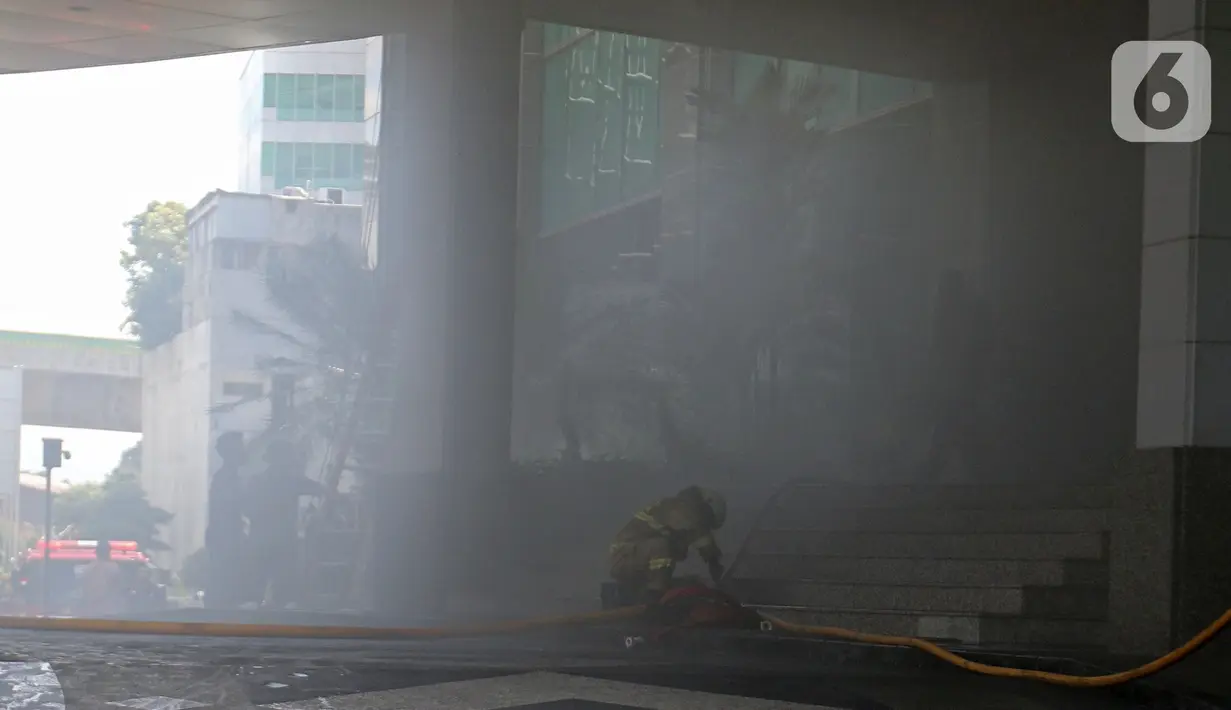 Petugas berusaha memadamkan kebakaran di Gedung Cyber 1, Jakarta, Kamis (2/12/2021). Suku Dinas Pemadam Kebakaran DKI Jakarta menurunkan 22 unit mobil pemadam kebakaran. (Liputan6.com/Herman Zakharia)