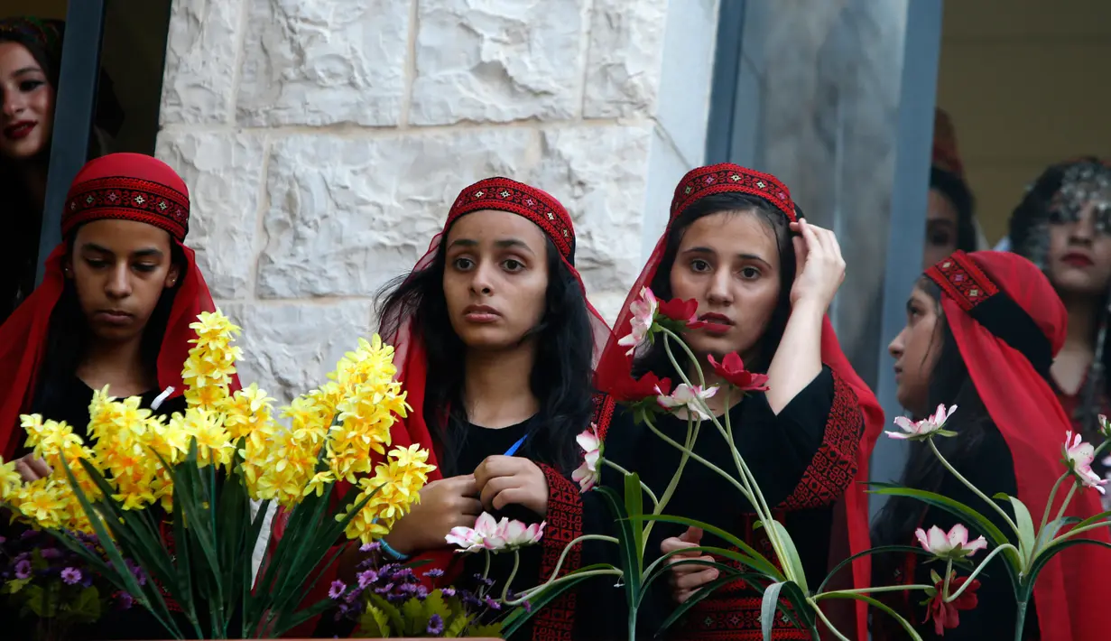 Sejumlah model menunggu giliran saatm mengikuti peragaan busana tradisional Palestina di Kota Tua Nablus, Tepi Barat, Palestina, Selasa (22/8). Peragaan busana ini sebagai salah satu upaya untuk melestarikan budaya Palestina. (AFP Photo/Jaafar Ashtiyeh)