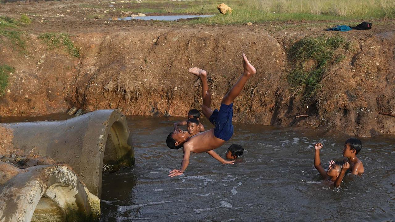 FOTO: Keceriaan Anak-Anak Bermain Pada Saluran Air di Tanjung Pasir