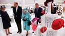 Ratu Elizabeth II melihat-lihat aksesoris topi di department store Fenwick saat mengunjungi pusat perbelanjaan Lexicon di Bracknell, London, Jumat (19/10). Ratu Elizabeth berjalan mengamati aksesoris sambil memegang buket bunga. (HENRY NICHOLLS/ POOL/AFP)
