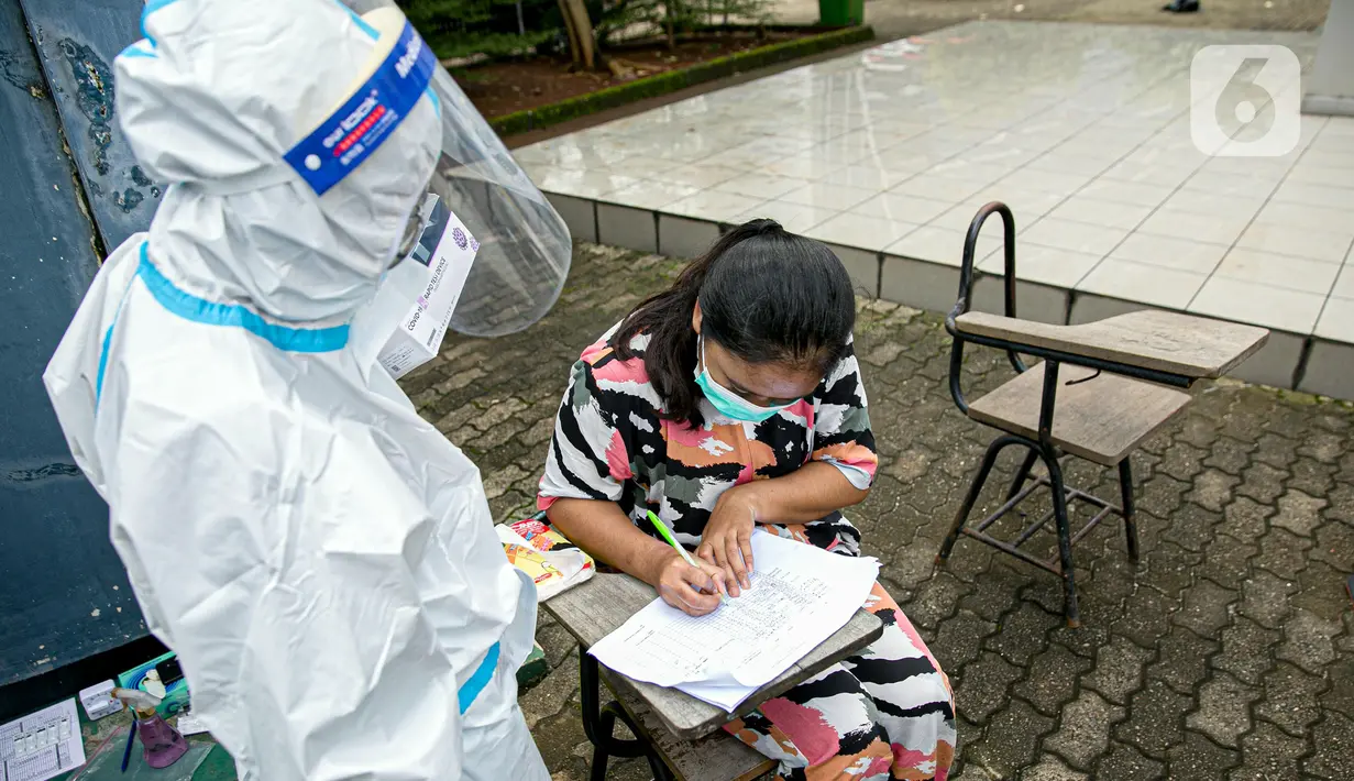 Pengungsi banjir mengisi data saat mengikuti swab antigen COVID-19 di Universitas Borobudur, Cipinang Melayu, Jakarta, Minggu (21/2/2021). Swab antigen COVID-19 terhadap pengungsi dilakukan mengingat di pengungsian mereka tidur berhimpitan. (Liputan6.com/Faizal Fanani)