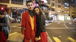 Pasangan mengenakan kostum Halloween berdiri di sebuah jalan di Hong Kong, Kamis (31/10/2019). Polisi Hong Kong bersiap untuk berjaga unjuk rasa Kamis malam, yang akan menguji peraturan larangan pemerintah untuk menutup wajah yang diperkenalkan bulan ini. (AP Photo/Kin Cheung)
