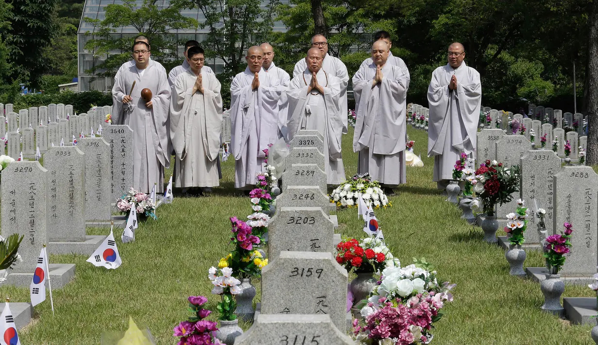 Para biksu Buddha berdoa di makam para tentara yang gugur untuk negara pada Memorial Day di Pemakaman Nasional Seoul, Korea Selatan, Kamis (6/6/2019). Memorial Day didedikasikan untuk mengingat prajurit dan warga sipil yang gugur selama perang Korea antara 1950-1953. (AP/Ahn Young-joon)