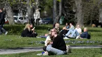 Orang-orang menikmati makan siang dengan menjaga jarak di Taman Humlegarden, Stockholm, Rabu (22/4/2020). Swedia belum memberlakukan lockdown, namum pemerintah memberikan tanggung jawab yang besar kepada penduduknya untuk membantu mengurangi penyebaran virus corona. (Janerik Henriksson / TT via AP)