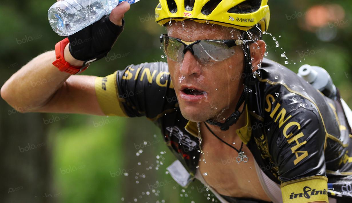 Pebalap dari tim Singha Infinite Cycling menyiram air ke wajahnya saat melintasi jalur tanjakan kelok 44  etape ke-4 Tour de Singkarak 2016 di Kabupaten Agam, Sumatera Barart. (Bola.com/NIcklas Hanoatubun)