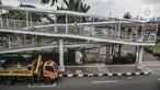 Petugas Sudin Bina Marga Jakarta Timur memperbaiki jembatan penyeberangan orang (JPO) di Jalan Otto Iskandardinata (Otista), Jatinegara, Rabu (9/2/2022). Perbaikan JPO itu tindak lanjut pasca insiden tertimpa pohon tumbang pada November tahun lalu akibat cuaca ekstrem. (merdeka.com/Iqbal S Nugroho)