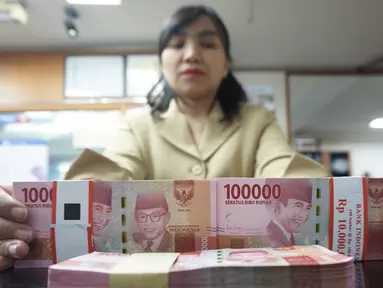 Teller menunjukkan mata uang rupiah di penukaran uang di Jakarta, Rabu (10/7/2019). Nilai tukar rupiah terhadap dolar Amerika Serikat (AS) ditutup stagnan di perdagangan pasar spot hari ini di angka Rp 14.125. (Liputan6.com/Angga Yuniar)