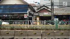 Kondisi pagar pembatas jalur transjakarta yang ditopang bambu di Jalan Otista Raya, Jakarta, Jumat (5/7/2019). Meskipun telah lama rusak, pagar besi berjeruji yang berfungsi sebagai pembatas agar orang tidak menyeberang secara sembarangan itu belum juga diperbaiki. (Liputan6.com/Immanuel Antonius)