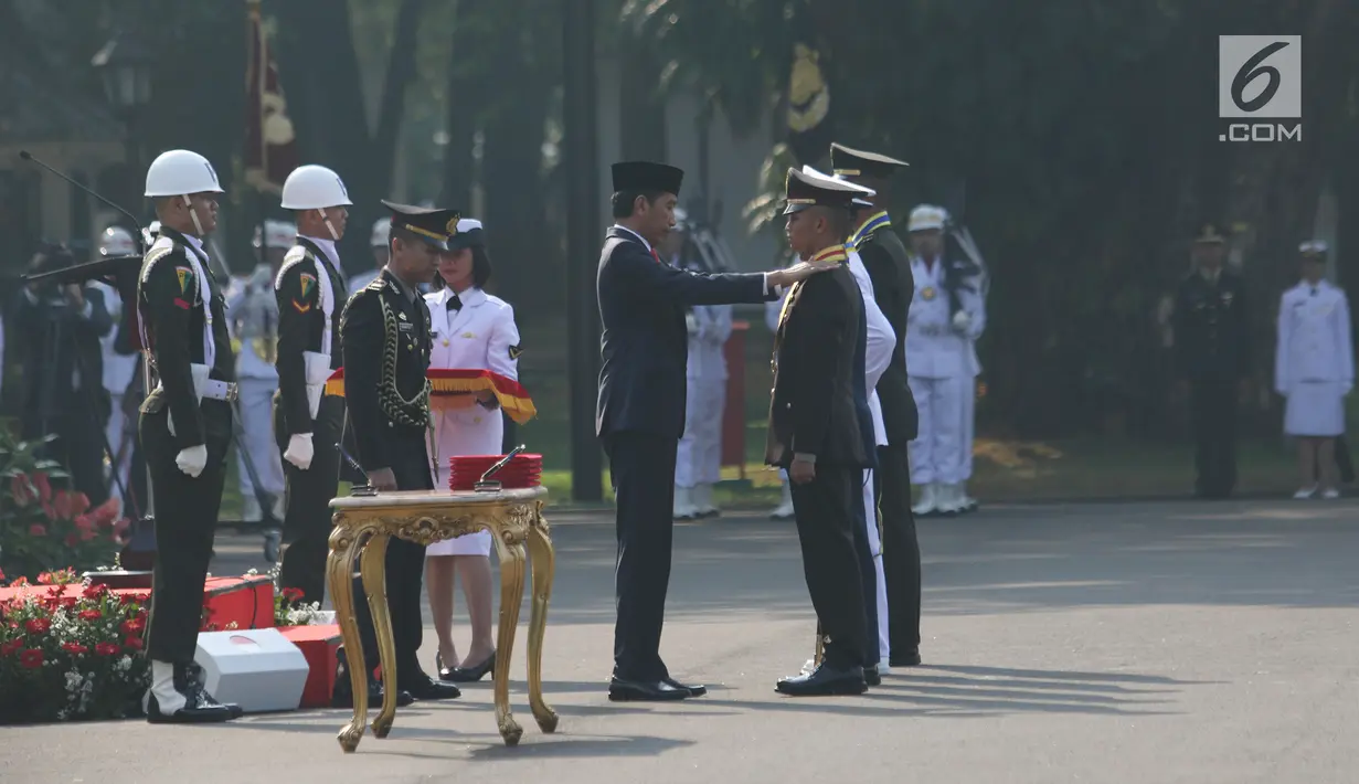 Presiden Joko Widodo (Jokowi) menyematkan tanda pangkat kepada salah satu perwira baru lulusan Akmil pada upacara Prasetya Perwira (Praspa) TNI dan Polri angkatan 2019 di Istana Merdeka, Kamis (16/7/2019). Ada 781 calon perwira yang dilantik oleh Jokowi. (Liputan6.com/Angga Yuniar)