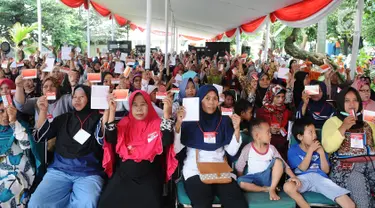 Warga menunjukkan kartu keluarga sejahtera saat Penyaluran Bantuan Sosial Program Keluarga Harapan (PKH) tahun 2019 dan Bantuan Pangan Non Tunai (BPNT) di Depok, Jawa Barat, Selasa (12/2). (Liputan6.com/Herman Zakharia)