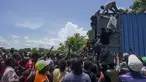 Warga naik ke truk yang penuh dengan pasokan bantuan untuk korban gempa, di Vey Terre, Haiti, Jumat (20/8/2021). Bantuan swasta dan kiriman dari pemerintah AS dan lainnya tiba di semenanjung barat daya negara itu yang dilanda gempa 7,2 gempa berkekuatan 14 Agustus. (AP Photo/Fernando Llano)